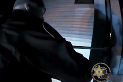 Sergeant Adam Claveau of the Mason County (Michigan) Sheriff's Office stands on the cab roof of his agency pickup and uses a crowbar to break off barriers on the balconies of apartments so that people can be rescued from a Monday fire.