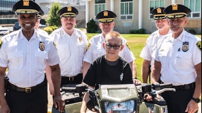 Kidney failure patient Wyatt atop a Suffolk County Sheriff's Office motorcycle and surrounded by Sheriff Errol Toulon Jr. and deputies.