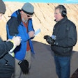 Me in the black hoodie interviewing an industry rep about a pistol I just shot...badly on a SHOT Show range.